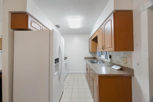 6639 Winding Oak Dr, Tampa, FL 33625 - kitchen featuring white appliances, a textured ceiling, a sink, light tile patterned floors, and backsplash