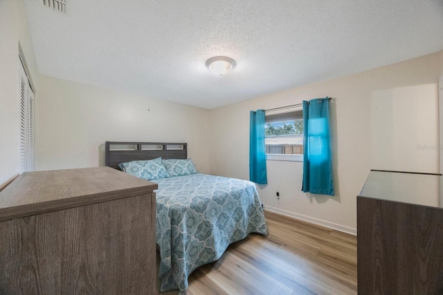 6639 Winding Oak Dr, Tampa, FL 33625 - bedroom featuring wood finished floors, a textured ceiling, and baseboards
