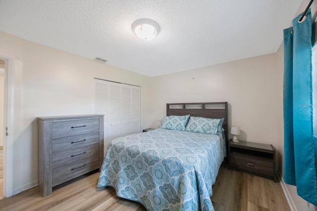 6639 Winding Oak Dr, Tampa, FL 33625 - bedroom with wood finished floors, a textured ceiling, baseboards, and a closet