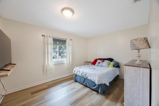 6639 Winding Oak Dr, Tampa, FL 33625 - bedroom featuring wood finished floors, baseboards, and a textured ceiling