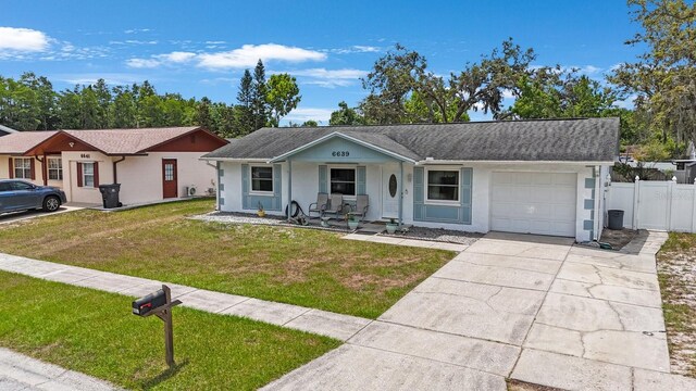 6639 Winding Oak Dr, Tampa, FL 33625 - ranch-style home with an attached garage, a porch, stucco siding, and driveway