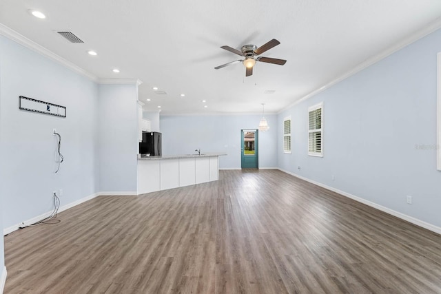 11016 Kiskadee Cir, New Port Richey, FL 34654 - unfurnished living room featuring crown molding, ceiling fan, baseboards, recessed lighting, and wood finished floors
