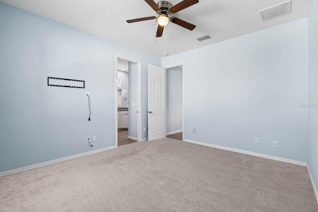 11016 Kiskadee Cir, New Port Richey, FL 34654 - unfurnished bedroom featuring carpet, baseboards, connected bathroom, and ceiling fan