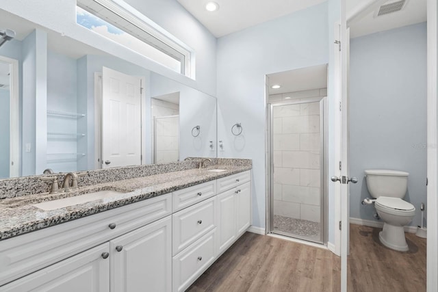 11016 Kiskadee Cir, New Port Richey, FL 34654 - bathroom featuring a shower stall, double vanity, wood finished floors, toilet, and baseboards