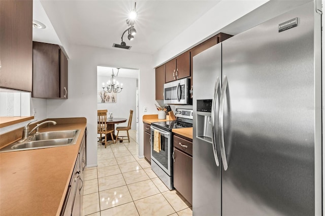 1410 Brighton Ct, Palm Harbor, FL 34684 - kitchen with stainless steel appliances, a sink, light tile patterned floors, and dark brown cabinets