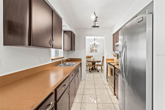 1410 Brighton Ct, Palm Harbor, FL 34684 - kitchen with appliances with stainless steel finishes, a sink, dark brown cabinets, a chandelier, and pendant lighting