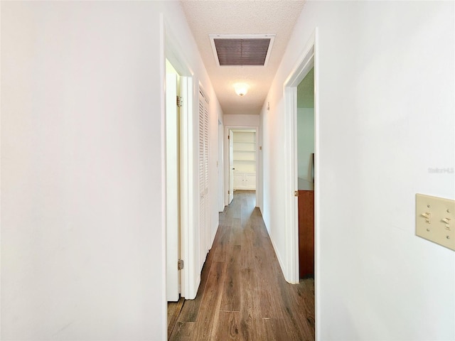 4102 Stonehenge Rd, Mulberry, FL 33860 - corridor featuring wood finished floors, a textured ceiling, and baseboards