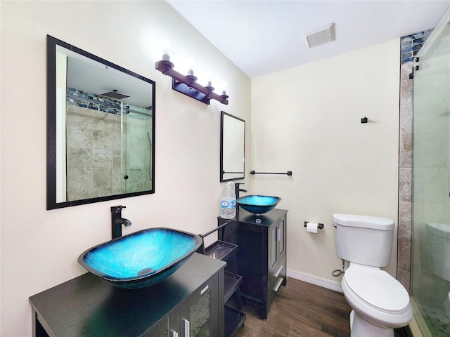 4102 Stonehenge Rd, Mulberry, FL 33860 - full bath with wood finished floors, a stall shower, baseboards, two vanities, and toilet