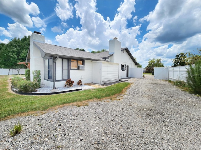 4102 Stonehenge Rd, Mulberry, FL 33860 - view of front facade with a gate, a chimney, brick siding, gravel driveway, and roof with shingles