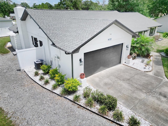 4102 Stonehenge Rd, Mulberry, FL 33860 - view of front of property with a garage, a shingled roof, concrete driveway, central air condition unit, and a chimney