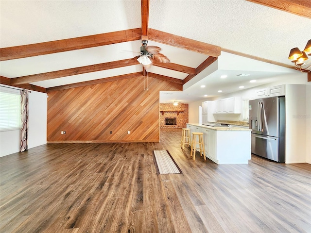 4102 Stonehenge Rd, Mulberry, FL 33860 - unfurnished living room featuring wooden walls, a fireplace, and wood finished floors