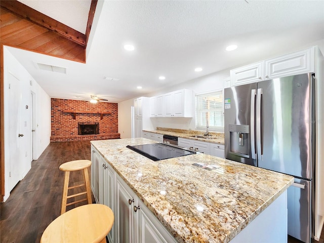 4102 Stonehenge Rd, Mulberry, FL 33860 - kitchen featuring stainless steel refrigerator with ice dispenser, brick wall, a kitchen island, dark wood-style floors, and white cabinetry