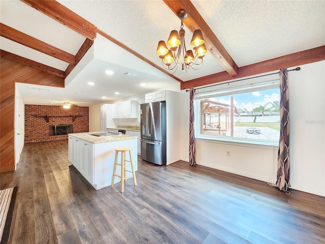 4102 Stonehenge Rd, Mulberry, FL 33860 - kitchen featuring stainless steel fridge with ice dispenser, a chandelier, white cabinetry, a textured ceiling, and a fireplace