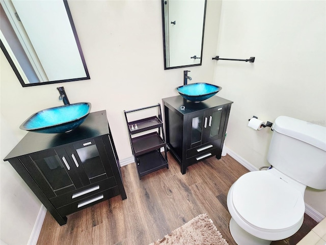 4102 Stonehenge Rd, Mulberry, FL 33860 - bathroom with baseboards, wood finished floors, vanity, and toilet