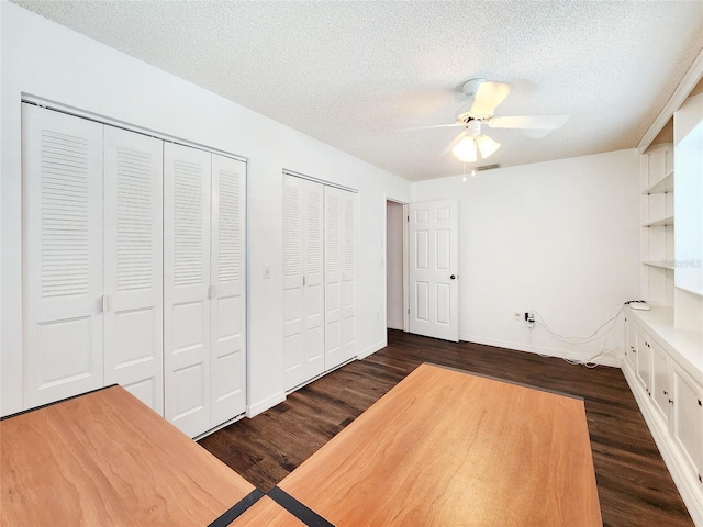 4102 Stonehenge Rd, Mulberry, FL 33860 - unfurnished bedroom featuring dark wood-type flooring, two closets, a textured ceiling, ceiling fan, and baseboards