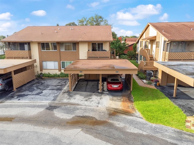 4036 Davit Dr, New Port Richey, FL 34652 - rear view of property featuring stairway, stucco siding, covered parking, and central air condition unit
