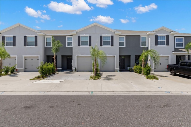 34248 Redwood Dawn Ln, Wesley Chapel, FL 33543 - townhome / multi-family property with an attached garage, driveway, and stucco siding