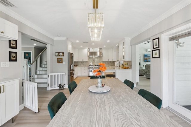 1709 Main St, Safety Harbor, FL 34695 - dining area with light wood-style flooring, ornamental molding, stairway, a chandelier, and recessed lighting
