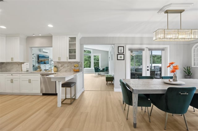 1709 Main St, Safety Harbor, FL 34695 - dining area featuring light wood-style floors, french doors, a wall unit AC, and recessed lighting