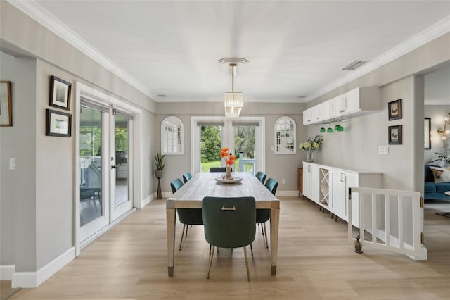 1709 Main St, Safety Harbor, FL 34695 - dining area featuring light wood-type flooring, ornamental molding, baseboards, and plenty of natural light