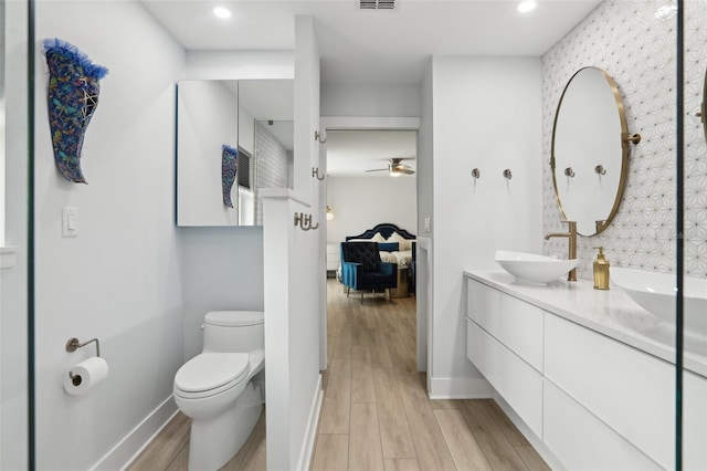 1709 Main St, Safety Harbor, FL 34695 - ensuite bathroom featuring double vanity, ceiling fan, wood finished floors, toilet, and recessed lighting