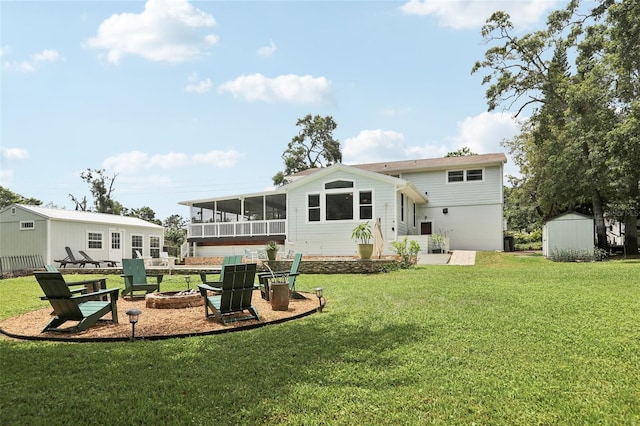 1709 Main St, Safety Harbor, FL 34695 - back of house featuring an outdoor fire pit, a sunroom, a lawn, and a patio area