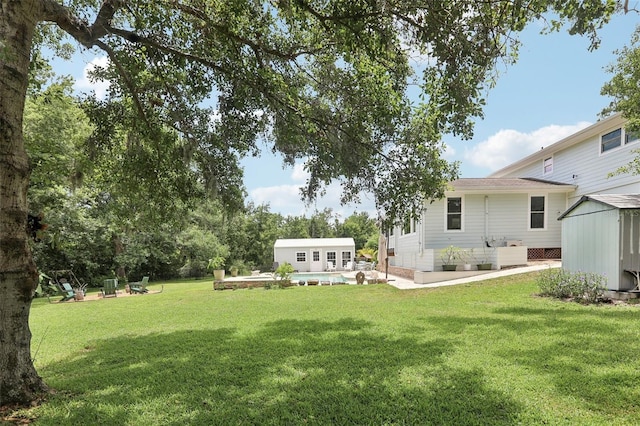 1709 Main St, Safety Harbor, FL 34695 - view of green lawn with an outdoor structure, a patio, and a pool