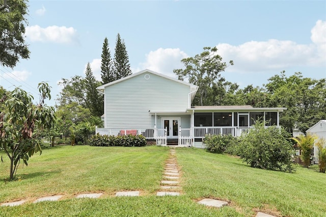 1709 Main St, Safety Harbor, FL 34695 - rear view of property with a sunroom, a yard, and french doors