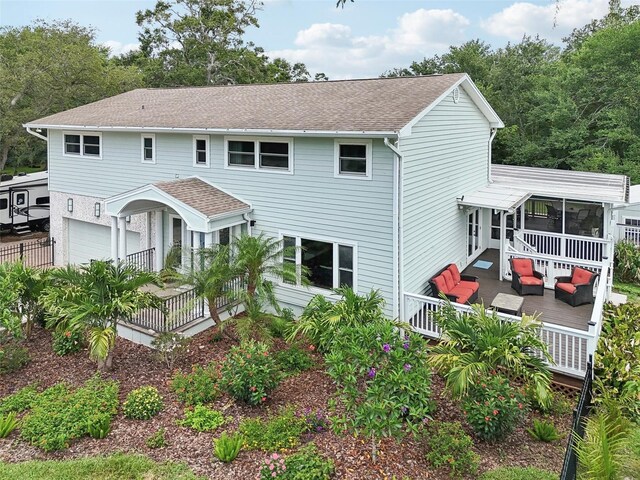 1709 Main St, Safety Harbor, FL 34695 - view of front facade featuring outdoor lounge area, an attached garage, a sunroom, and a shingled roof