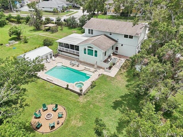 1709 Main St, Safety Harbor, FL 34695 - back of property with roof with shingles, a patio area, a pool with connected hot tub, a sunroom, and a lawn