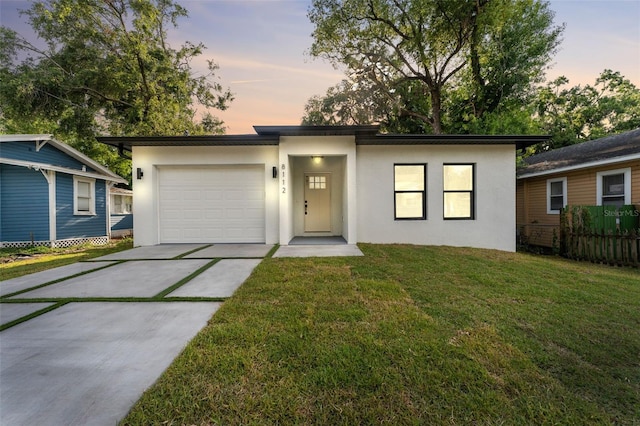 8112 N 10th St, Tampa, FL 33604 - view of front of house with stucco siding, driveway, a lawn, and an attached garage