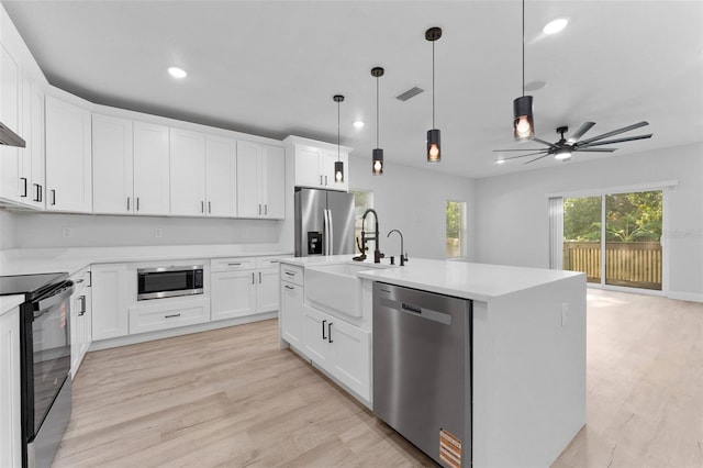 8112 N 10th St, Tampa, FL 33604 - kitchen featuring stainless steel appliances, a sink, light countertops, ceiling fan, and light wood finished floors
