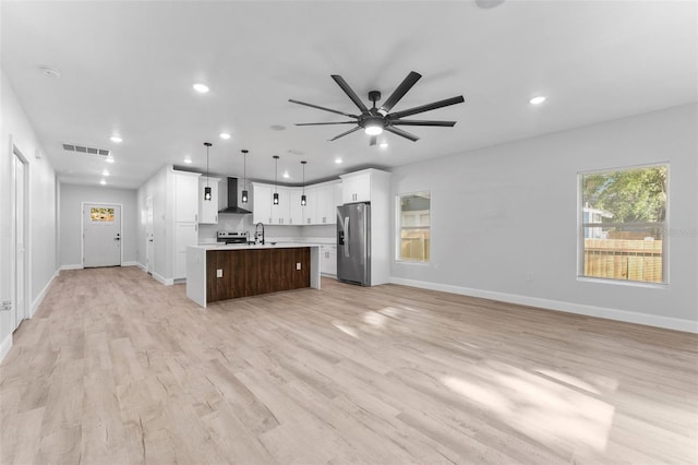 8112 N 10th St, Tampa, FL 33604 - kitchen with stainless steel fridge, open floor plan, wall chimney range hood, light countertops, and a kitchen island with sink