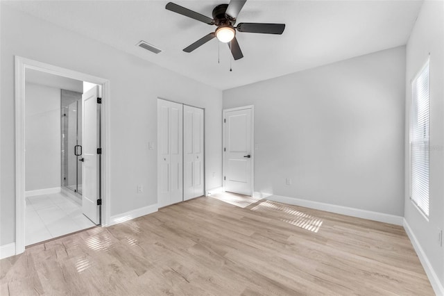 8112 N 10th St, Tampa, FL 33604 - unfurnished bedroom with light wood-style floors, baseboards, connected bathroom, a closet, and a ceiling fan