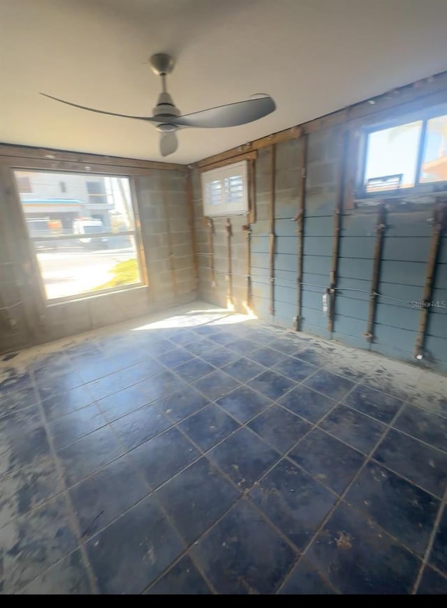 709 Pruitt Dr, Madeira Beach, FL 33708 - unfurnished room with plenty of natural light, ceiling fan, and dark tile patterned flooring