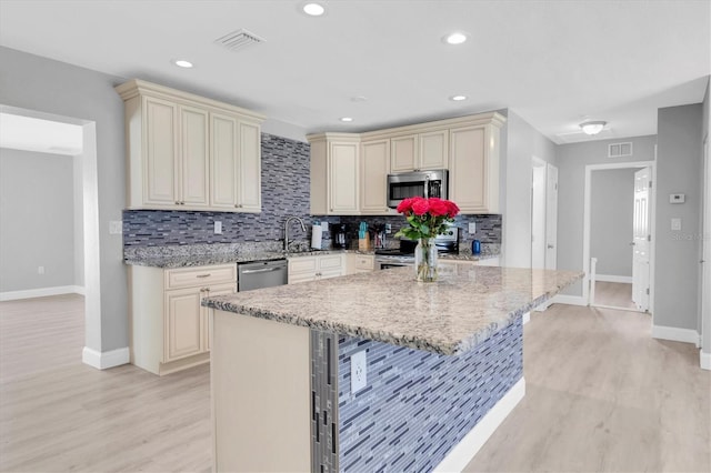 5685 35th Ave N, Saint Petersburg, FL 33710 - kitchen featuring cream cabinetry, stainless steel appliances, baseboards, tasteful backsplash, and recessed lighting