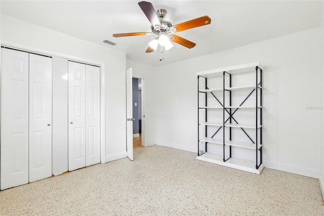 8525 N Ola Ave, Tampa, FL 33604 - unfurnished bedroom with speckle patterned floor, a closet, baseboards, and a ceiling fan
