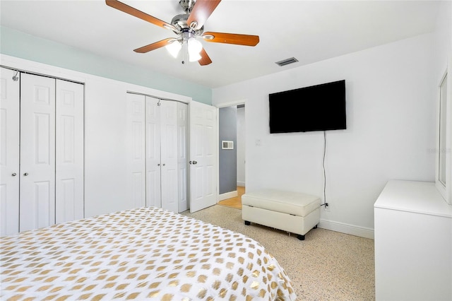 8525 N Ola Ave, Tampa, FL 33604 - bedroom featuring multiple closets, baseboards, dark speckled floor, and ceiling fan