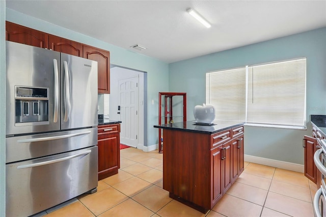 8525 N Ola Ave, Tampa, FL 33604 - kitchen with stainless steel fridge, dark brown cabinets, light tile patterned floors, baseboards, and a kitchen island