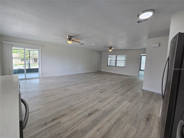 17 Oak Loop, Ocala, FL 34472 - unfurnished living room featuring a ceiling fan, light wood-style floors, a textured ceiling, and baseboards