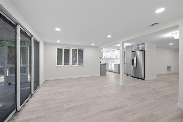 15025 Shark St, Hudson, FL 34667 - unfurnished living room featuring light wood-style floors, plenty of natural light, recessed lighting, and baseboards