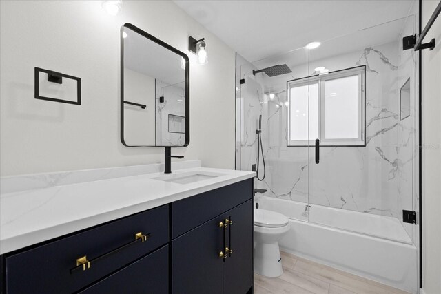 15025 Shark St, Hudson, FL 34667 - bathroom featuring toilet, vanity, enclosed tub / shower combo, and wood finished floors
