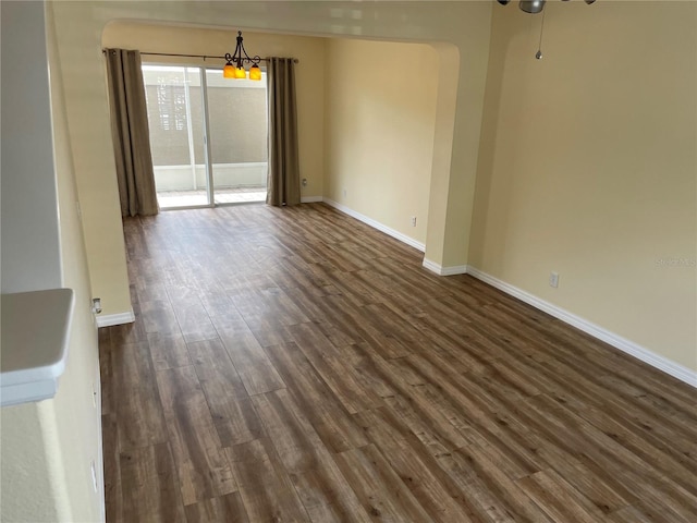 13290 Thoroughbred Loop, Largo, FL 33773 - spare room with a chandelier, dark wood-type flooring, and arched walkways