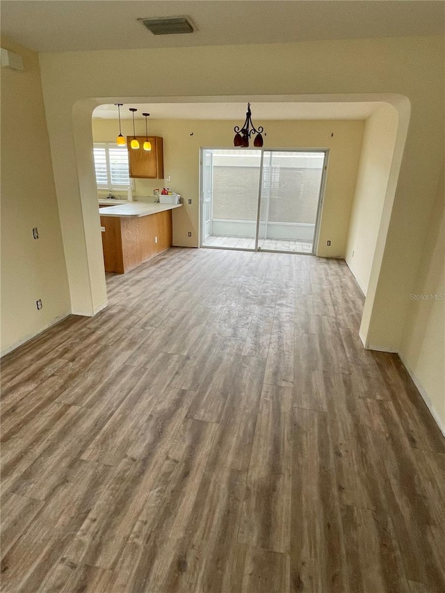 13290 Thoroughbred Loop, Largo, FL 33773 - unfurnished living room with wood finished floors, arched walkways, and a chandelier