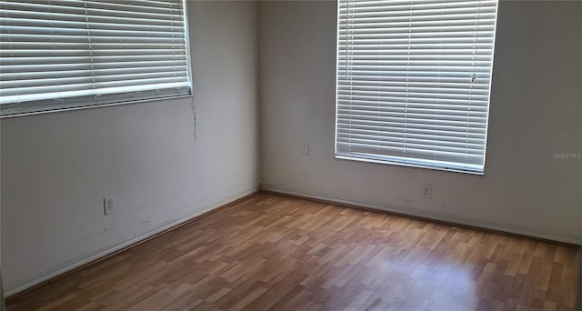 2603 Mary Sue St SW, Largo, FL 33774 - spare room with wood finished floors, healthy amount of natural light, and baseboards
