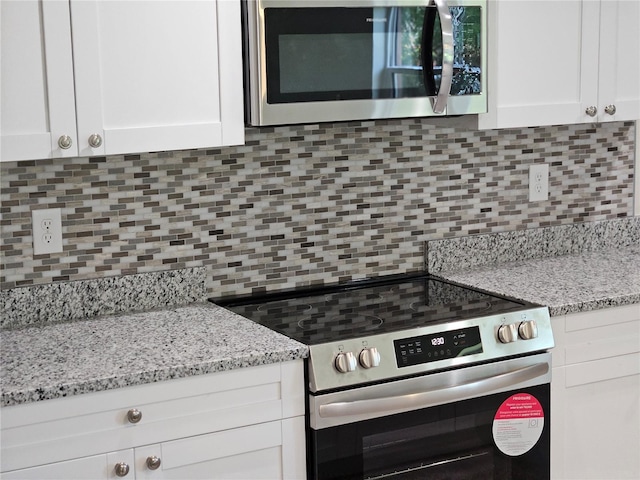 11210 Mcmullen Rd, Riverview, FL 33569 - kitchen featuring appliances with stainless steel finishes, tasteful backsplash, white cabinets, and light stone countertops