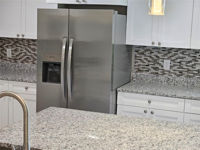 11210 Mcmullen Rd, Riverview, FL 33569 - kitchen with stainless steel refrigerator with ice dispenser, backsplash, white cabinetry, and light stone counters