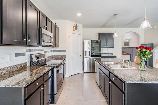 30989 Summer Sun Loop, Wesley Chapel, FL 33545 - kitchen with appliances with stainless steel finishes, a sink, decorative backsplash, and an island with sink