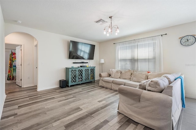 30989 Summer Sun Loop, Wesley Chapel, FL 33545 - living room featuring arched walkways, light wood-style floors, a chandelier, and baseboards