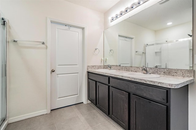 30989 Summer Sun Loop, Wesley Chapel, FL 33545 - bathroom with double vanity, a stall shower, tile patterned floors, and baseboards